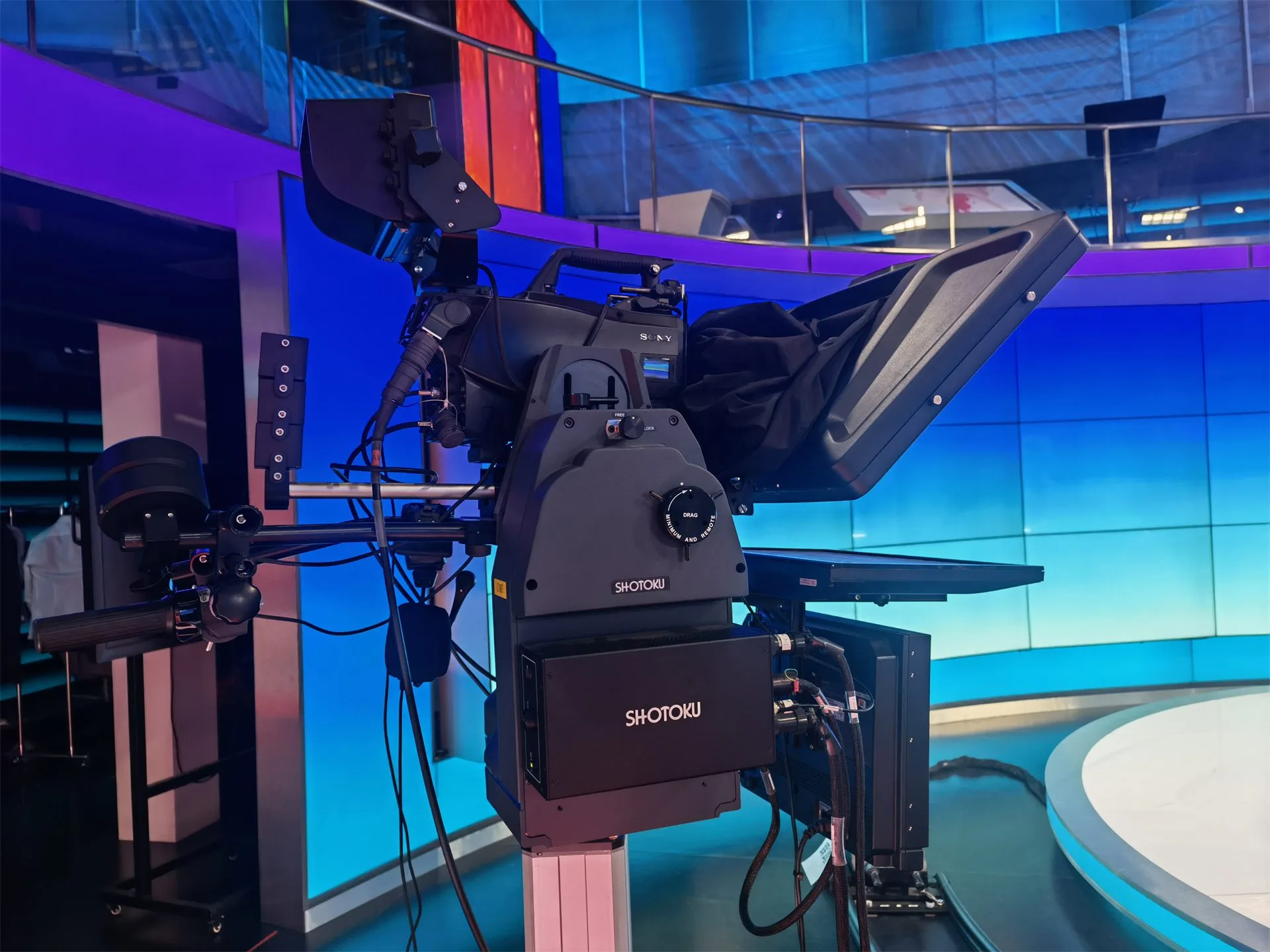 Studio Teleprompter Ultra mounted on a broadcast camera in a blue-lit studio